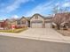 Attractive home boasting a three-car garage, stone accents, and manicured front yard at 10770 Hillrose St, Parker, CO 80134