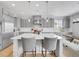 Bright, modern kitchen features gray cabinets, stainless steel appliances, and a large center island with seating at 10770 Hillrose St, Parker, CO 80134
