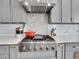 Close-up of a stainless steel range with gray cabinets, white subway tile backsplash, and quartz countertops at 10770 Hillrose St, Parker, CO 80134