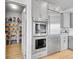 Kitchen with stainless steel refrigerator and ovens, plus pantry with shelving and organized storage baskets at 10770 Hillrose St, Parker, CO 80134