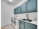 Practical laundry room with modern appliances, cabinets, sink, and ample counter space at 10770 Hillrose St, Parker, CO 80134