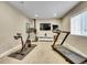 Home gym with cardio equipment, a TV, and a window for natural light at 10770 Hillrose St, Parker, CO 80134