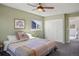 Well-lit bedroom with a bed, closet, and window offering a view of a blue house at 11446 W 105Th Dr, Broomfield, CO 80021