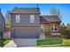 Charming two-story home featuring a well-manicured lawn, a two-car garage, and a cozy brick porch area at 11446 W 105Th Dr, Broomfield, CO 80021