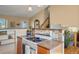 Kitchen area featuring an electric stovetop, tiled backsplash, and open staircase access to the upper level at 11446 W 105Th Dr, Broomfield, CO 80021