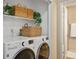 Functional laundry room with front load washer and dryer, ample storage, and access to a nearby bathroom at 11446 W 105Th Dr, Broomfield, CO 80021