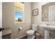 Small bathroom with pedestal sink, toilet and window at 2866 Low Meadow Blvd, Castle Rock, CO 80109