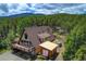 Aerial view of A-frame home in wooded setting, featuring the deck and outbuilding at 8691 S Warhawk Rd, Conifer, CO 80433