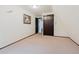 A simple bedroom with light-colored carpeting, a dark wood closet, and a window at 8691 S Warhawk Rd, Conifer, CO 80433