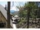 Large deck with outdoor dining area and mountain views surrounded by pine trees at 8691 S Warhawk Rd, Conifer, CO 80433