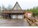 A-frame home featuring a two-car garage, wooden deck, and wood storage at 8691 S Warhawk Rd, Conifer, CO 80433