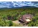 A-frame home nestled in a forest, boasting a large deck and separate shed at 8691 S Warhawk Rd, Conifer, CO 80433