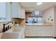Bright kitchen featuring white cabinets, tiled backsplash, and natural stone countertops at 8691 S Warhawk Rd, Conifer, CO 80433