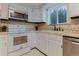 Corner of kitchen featuring white cabinets, stove, and tile backsplash at 8691 S Warhawk Rd, Conifer, CO 80433