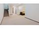 Spacious living room featuring neutral carpeting and a staircase to the upper level at 8691 S Warhawk Rd, Conifer, CO 80433