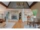 Open-concept living area with a stone fireplace, wood floors, and a view into the kitchen at 8691 S Warhawk Rd, Conifer, CO 80433
