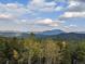 Breathtaking mountain view with lush green trees under a beautiful blue sky with clouds at 8691 S Warhawk Rd, Conifer, CO 80433