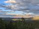 Scenic view of rolling hills and distant mountains under a partly cloudy sky at 8691 S Warhawk Rd, Conifer, CO 80433