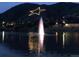 Nighttime aerial view of a town with a water fountain and starlit mountain at 110 Oakdale Dr, Palmer Lake, CO 80133