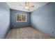 A blue bedroom with a ceiling fan and a window at 16185 Willowstone St, Parker, CO 80134