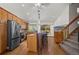 Well-lit kitchen with stainless appliances, a central island with bar stools, and staircase access at 16185 Willowstone St, Parker, CO 80134