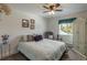 Inviting bedroom with a comfortable bed, a ceiling fan, and a window overlooking a lush yard at 10640 W 46Th Ave, Wheat Ridge, CO 80033