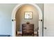 A charming hallway with an archway, a wooden dresser, and decorative accents at 10640 W 46Th Ave, Wheat Ridge, CO 80033