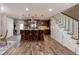 Spacious kitchen featuring wood floors, a large island with seating, and stairs with white trim at 10640 W 46Th Ave, Wheat Ridge, CO 80033