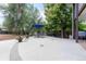 Large concrete patio perfect for entertaining, with outdoor seating and mature trees at 10640 W 46Th Ave, Wheat Ridge, CO 80033