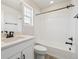 Bright bathroom featuring a tub with black hardware, a white sink with a window and neutral flooring at 4046 N Irvington St, Aurora, CO 80019