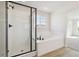 Modern bathroom with a glass-enclosed shower and a luxurious soaking tub by the window at 4046 N Irvington St, Aurora, CO 80019