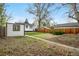 Backyard featuring a detached garage, mature trees, and well-maintained lawn area at 1960 S Franklin St, Denver, CO 80210