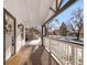 Inviting covered front porch with stained wood floors and white railing is perfect for relaxing and enjoying the outdoors at 1960 S Franklin St, Denver, CO 80210