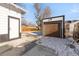 View of the detached one car garage and access door with snow on the ground at 1960 S Franklin St, Denver, CO 80210