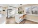 Modern white kitchen with stainless steel appliances, breakfast bar seating, and bright natural light at 1960 S Franklin St, Denver, CO 80210