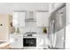 Bright kitchen features stainless steel appliances, white cabinetry, quartz countertops, and a stylish range hood at 1960 S Franklin St, Denver, CO 80210