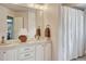 Well-lit bathroom featuring double sinks, vanity, and shower with white shower curtain at 16361 Parkside Dr, Parker, CO 80134