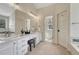 Bright bathroom featuring dual vanities, a walk-in shower, and a soaking tub at 16361 Parkside Dr, Parker, CO 80134