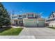 Charming two-story home featuring a well-manicured lawn, three-car garage, and beautiful green exterior at 16361 Parkside Dr, Parker, CO 80134
