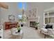 Bright living room featuring tall windows, fireplace, comfortable seating, and a grand piano at 16361 Parkside Dr, Parker, CO 80134