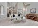 Bright living room with a modern sofa, round tables, piano, and an open staircase to the second floor at 16361 Parkside Dr, Parker, CO 80134