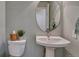 A powder room features a pedestal sink and a round mirror at 16361 Parkside Dr, Parker, CO 80134