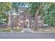 Charming brick apartment building with a gated entry and mature trees lining the front at 963 N Logan St # 11, Denver, CO 80203