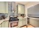 Modern kitchen with stainless steel appliances, light green cabinets, and stylish range hood at 963 N Logan St # 11, Denver, CO 80203