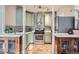 Well-lit kitchen with stainless steel appliances, stylish backsplash, and pale green cabinetry at 963 N Logan St # 11, Denver, CO 80203