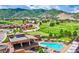 Aerial view of a clubhouse with a pool, lounge chairs, and golf course set against a scenic mountain landscape at 11160 Dolce Vita Pl, Littleton, CO 80125