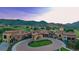 A circular drive highlights the clubhouse entrance with classic architecture and lush greenery with mountains in the background at 11160 Dolce Vita Pl, Littleton, CO 80125