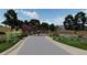 Elegant entrance gate to Dolce Vita Estates adorned with lush landscaping and stone pillars adds a touch of sophistication at 11160 Dolce Vita Pl, Littleton, CO 80125