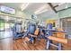 Well-equipped gym featuring modern workout equipment, wood floors, and glass walls overlooking outdoor seating at 11160 Dolce Vita Pl, Littleton, CO 80125