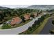 Street view of luxury homes with red tiled roofs, well-manicured lawns and mature trees in a tranquil community at 11160 Dolce Vita Pl, Littleton, CO 80125